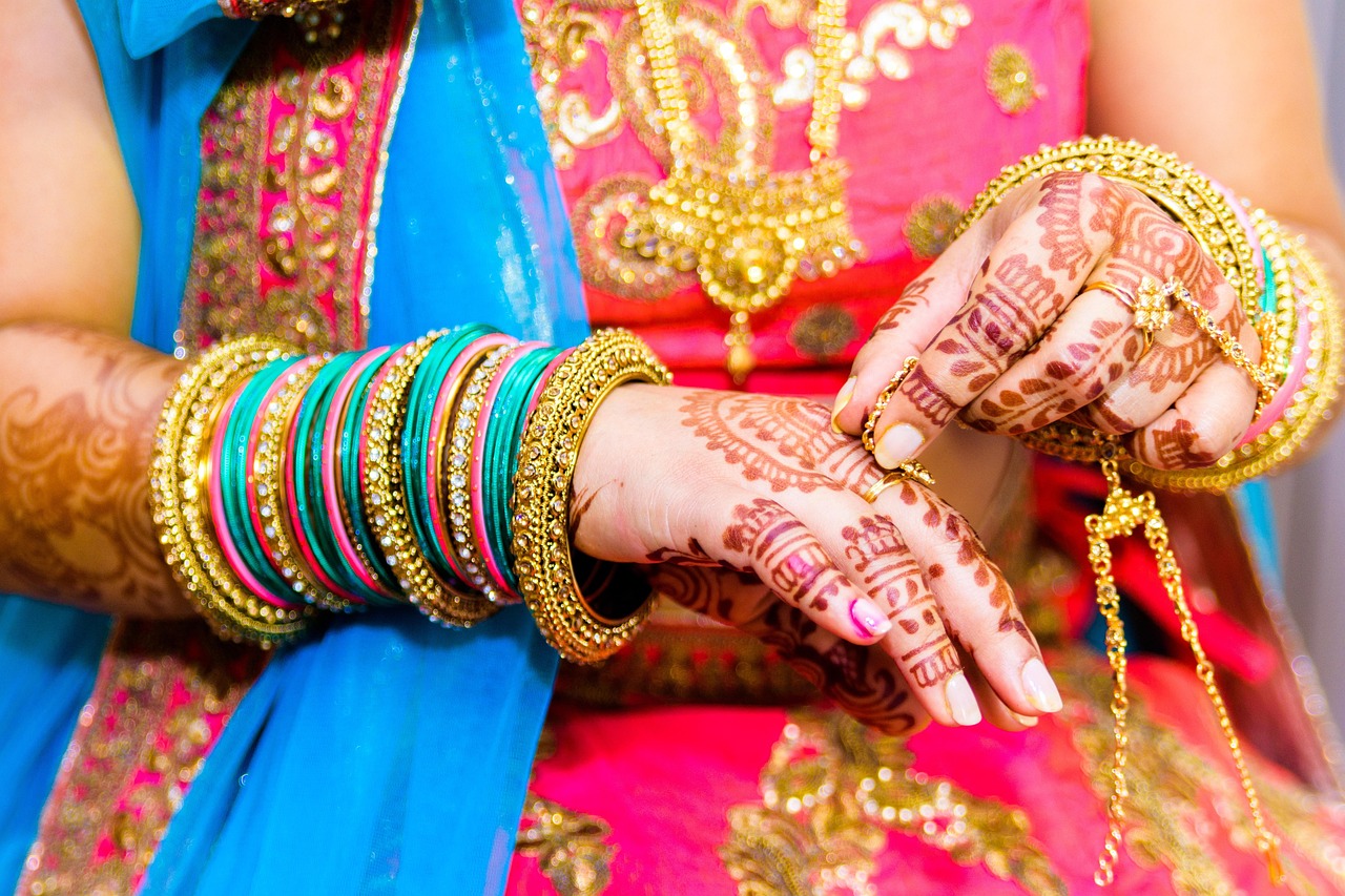 Showing Woman hand wearing gold jewellery in her wedding