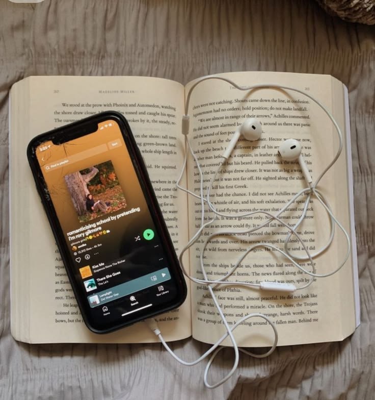 earphones connected with phone kept over a book