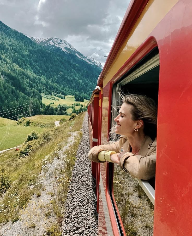 A girl peeking out the window of a train