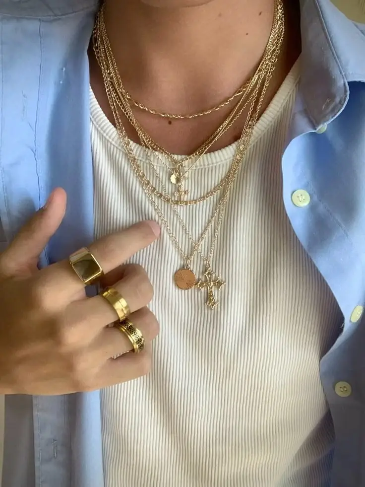 layered chains worn over a white T-shirt with blue shirt