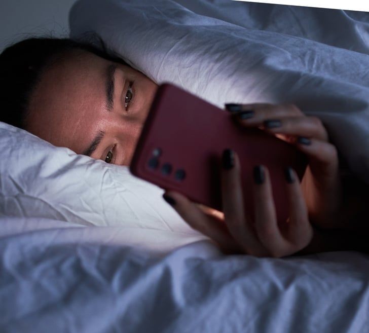 A woman looking at the phone at night